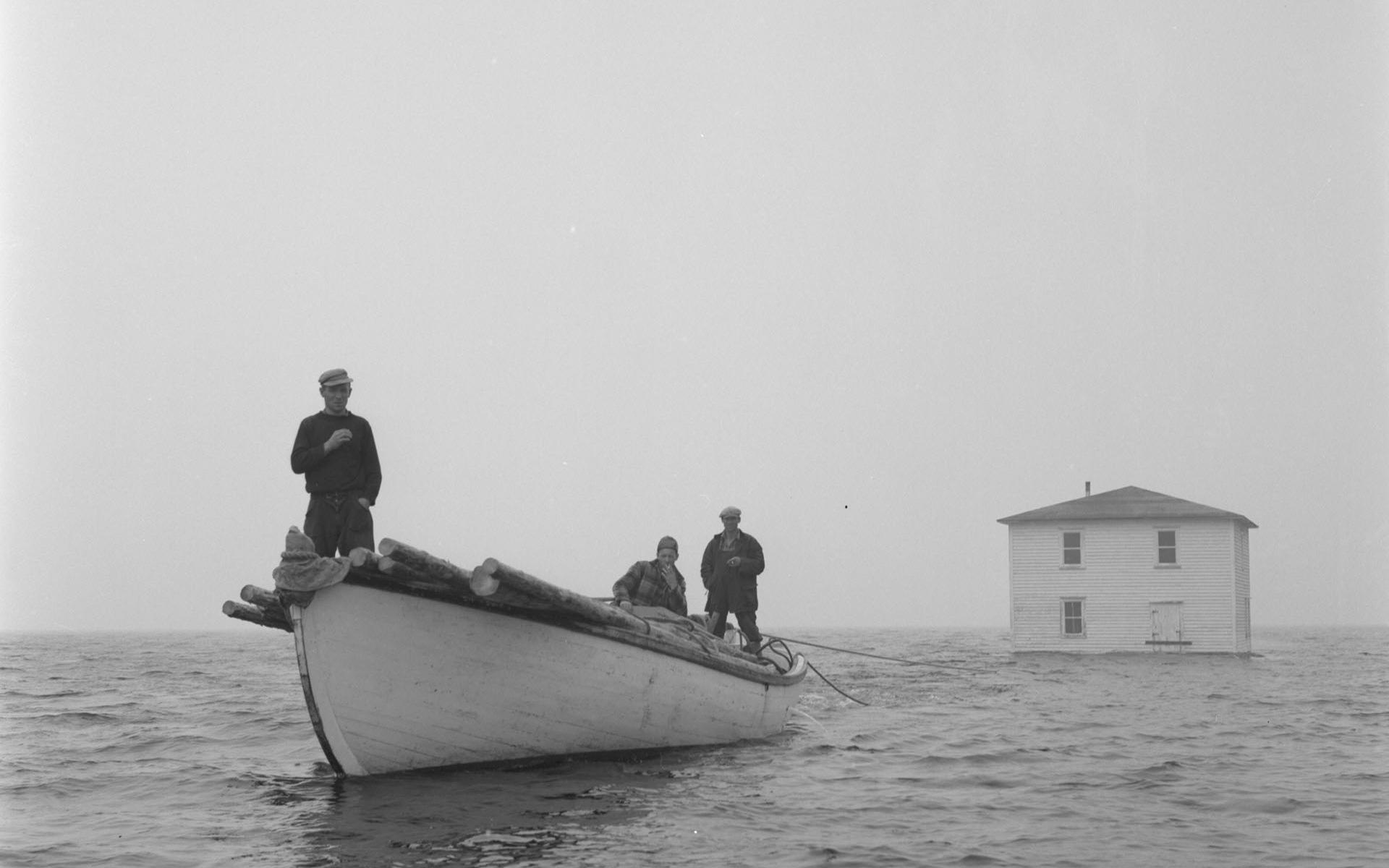 Une maison d’un village isolé de Terre-Neuve est tirée par un bateau de pêche.